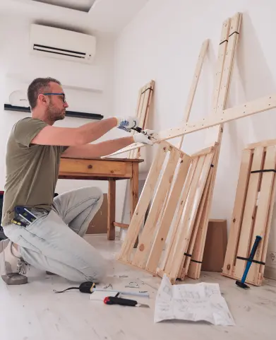 A man is working on some wooden furniture.